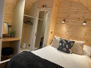 文斯福New Farm Cheshire Holidays的一间卧室设有一张带木墙的大床