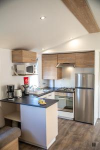 鲁西隆地区卡内amorosa mobil home的厨房配有不锈钢用具和木柜