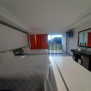 库埃纳瓦卡Hotel Borda Cuernavaca的酒店客房设有两张床和大窗户。