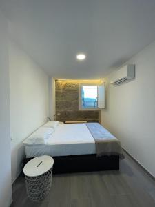 里瓦达维亚Cepas Da Cuenga的一间卧室配有一张带凳子和窗户的床