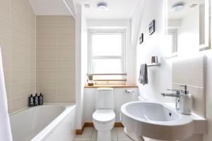 因弗内斯The Rooftops Reservation的白色的浴室设有浴缸、卫生间和水槽。