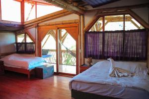 TzununáBambu Guest House的一间带两张床的卧室,位于带窗户的房间内