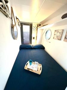 阿尔盖罗Houseboat Seabreeze的一张小房间的床,上面有托盘