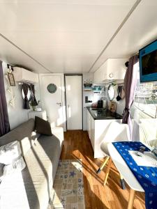 阿尔盖罗Houseboat Seabreeze的一个带沙发和桌子的大篷车以及一间厨房