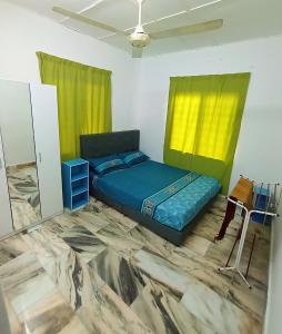 加央Simple Beseri Homestay的一间卧室配有床、桌子和黄色窗帘