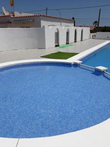 卡拉恩波特Tramontana Villa的白色建筑旁边的大型蓝色游泳池
