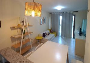 卡姆布库Escala VG Sun Cumbuco的一间带白色桌子的客厅和一间带沙发的房间