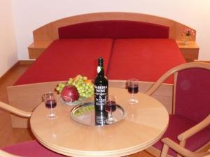 鲍洛通塞迈什BALATON ART Guesthouse的一张桌子,上面放着一瓶葡萄酒和两杯酒