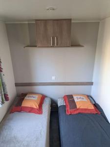 Saint-ChéronMobil home confort 6 personnes的小房间设有两张床和橱柜