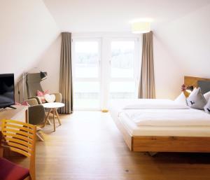 阿尔布斯塔特佐勒斯特格夫柏格酒店的一间卧室配有两张床、一张桌子和一台电视。