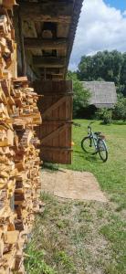 KoszeleDom Na Wsi u Ani的自行车旁建筑物边的一堆木头