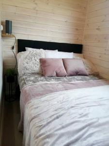 WapnicaTiny beach house heated and airconditioned的一张带粉红色和白色枕头的床