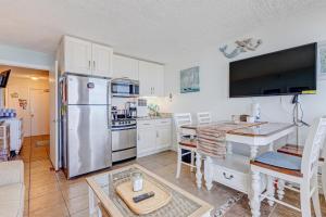代托纳海滩Harbour Beach Resort 611的厨房配有不锈钢冰箱和桌子