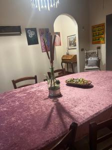 阿雷佐Casale di mamma Antonella的一张桌子,上面有粉红色的桌布和花瓶