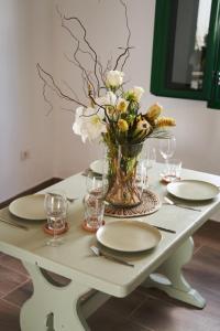 特吉塞CASA MINGO的一张桌子,上面有盘子和花瓶