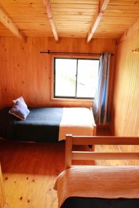 柯纳里佩Cabanas L'ESCALE的一间位于小屋内的卧室,配有一张床和一个窗户
