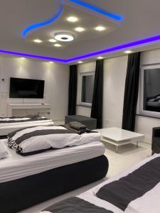 埃森Aparts House - Balkon-WiFi-Kitchen的一间卧室设有两张床,天花板上拥有蓝色的灯光。