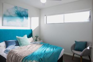 卡瓦纳华特斯Salt at Oceanside的一间卧室设有一张床、一个窗口和一把椅子
