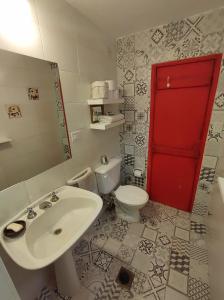 贝尔维尔Departamento amoblado的一间带卫生间、水槽和红色门的浴室