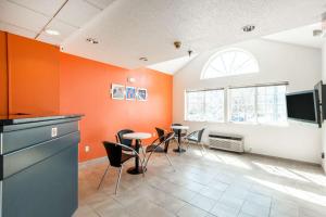 奥拉西奥拉西6号汽车旅馆的客房拥有橙色的墙壁和桌椅。