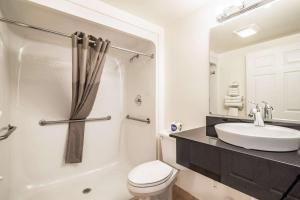 Lorenzo里格比6号汽车旅馆的浴室配有白色卫生间和盥洗盆。