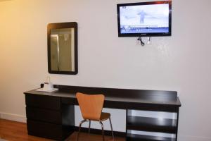 Goodland古德兰6号汽车旅馆的一张带镜子的桌子和墙上的电视