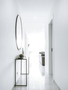 明德卢Filomena Apartments LUXURY的白色走廊,配有镜子和桌子