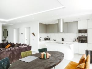 明德卢Filomena Apartments LUXURY的厨房以及带桌子和沙发的客厅。