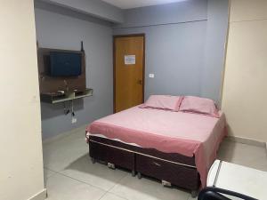 戈亚尼亚El Nassr suits的一间小卧室,配有一张床和电视