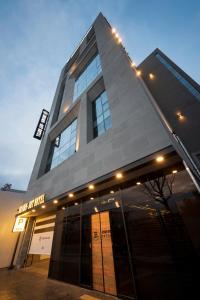 釜山Browndot hotel Guseo的一座高大的建筑,上面有灯