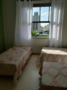 贝洛奥里藏特Espaço Inteiro para 08 pessoas próximo a área hospitalar em BH的一间卧室设有两张床和一个美景窗户。