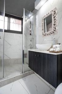 耶路撒冷Lovely 2 bedroom unit, Shivtey Israel, Jerusalem的带淋浴、盥洗盆和镜子的浴室