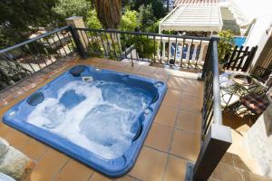 萨洛Buda Villa Planetcostadorada的庭院设有蓝色的热水浴缸和围栏