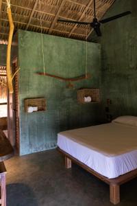 兹波利特COCOS HOTEL的一间卧室设有一张床和绿色的墙壁