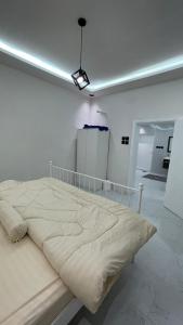 阿哈达بيت الجبل عوائل فقط的一张大床,位于白色的房间里,光线充足