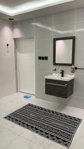 阿哈达بيت الجبل عوائل فقط的浴室设有水槽、镜子和地毯。