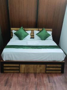 瓦亚纳德Misty Ghats Resort的一张带绿色枕头的床