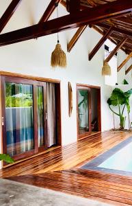 圣维森特Yumi Villas的客厅铺有木地板,设有窗户。