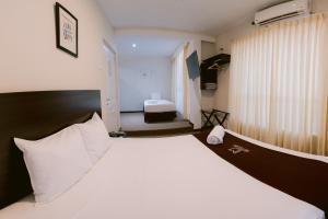 皮乌拉LM Hoteles的卧室配有带白色枕头的大床