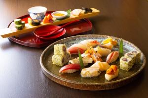 八幡平市ANA Crowne Plaza Resort Appi Kogen, an IHG Hotel的桌上放有寿司的盘子