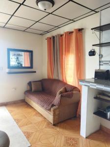 科隆Ofiuras Hostal的客厅里一张沙发,配有橙色窗帘