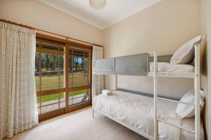 努尔卡巴The Fletcher Estate的一间卧室设有两张双层床和一扇窗户。