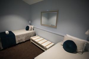 玛格丽特河Margaret River Mainstreet的小房间设有两张床和镜子