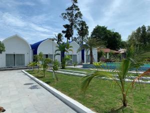 贡布Kampheak Roath Bungalows的一个带游泳池和棕榈树的度假村
