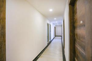 诺伊达FabExpress F9 Noida Sector 27的空的走廊设有白色的墙壁和木地板