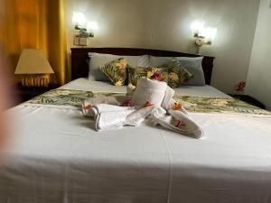 马埃岛贝拉扎尔区兰花日落旅馆的一张带白色毛巾和枕头的床