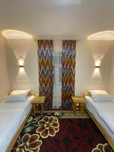 希瓦Naqqosh的客房设有两张床、一个窗户和两个灯