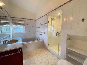 温哥华Cozy Dunbar 3 Beds Home w/ Views的带淋浴、盥洗盆和浴缸的浴室
