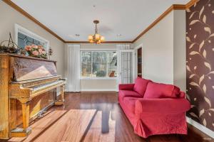 温哥华Cozy Dunbar 3 Beds Home w/ Views的客厅配有红色沙发和钢琴