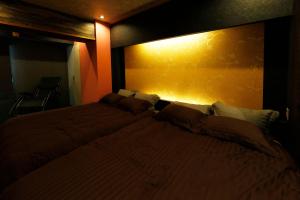 札幌MolinHotels501 -Sapporo Onsen Story- 1L2Room W-Bed4&S-6 10persons的一间卧室设有一张黄色墙壁的大床
